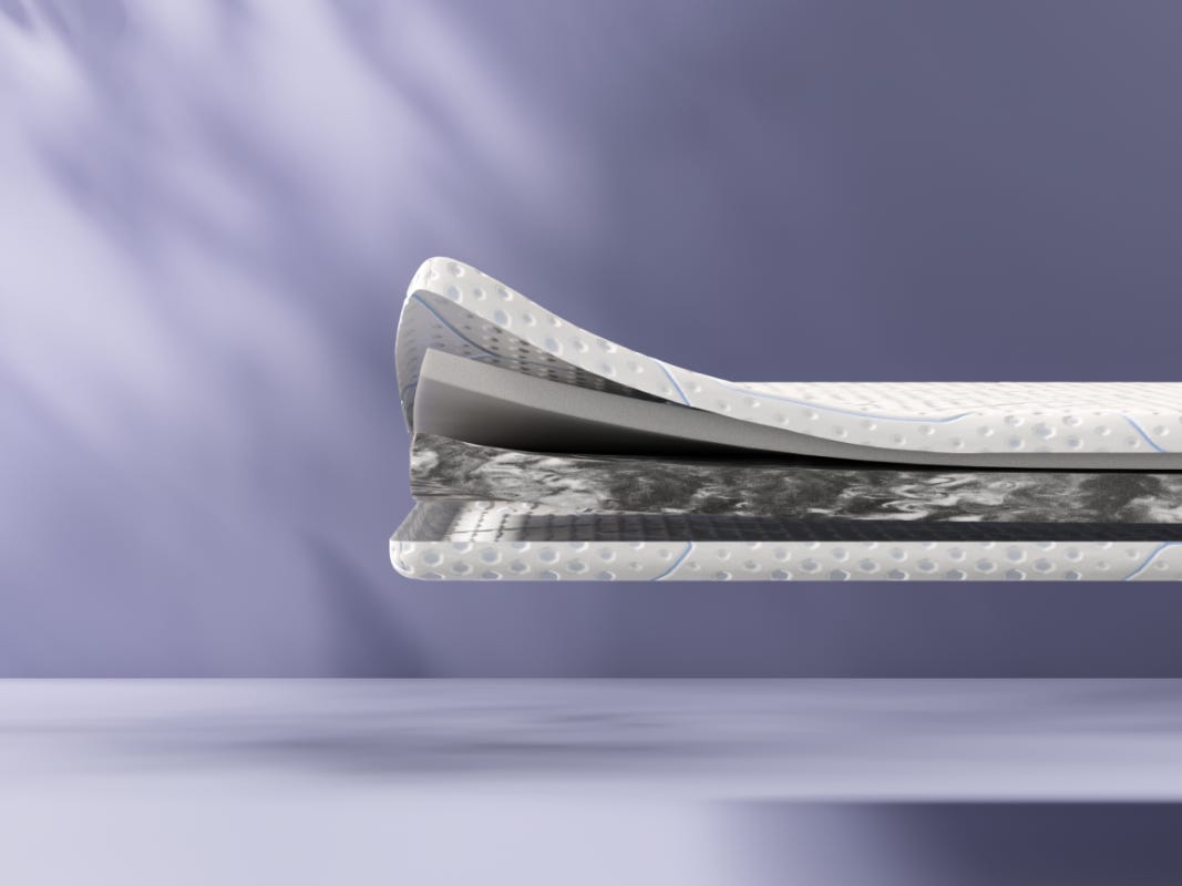 Doorsnede van de Emma Diamond Topper+, met meerdere lagen schuim en textiel in verschillende kleuren en texturen.